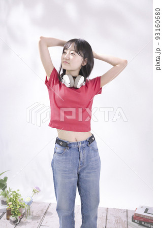 ヘッドフォンで音楽を聴く若い女性 93160680