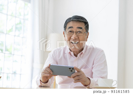 スマートフォンを持った笑顔のシニア男性 スマートフォンを持った笑顔のシニア男性 93161585