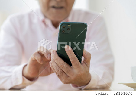 スマートフォン操作するシニア男性の手元 スマートフォン操作するシニア男性の手元 93161670