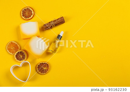 Flat lay composition with natural handmade soap and ingredients on yellow background. Space for text 93162230