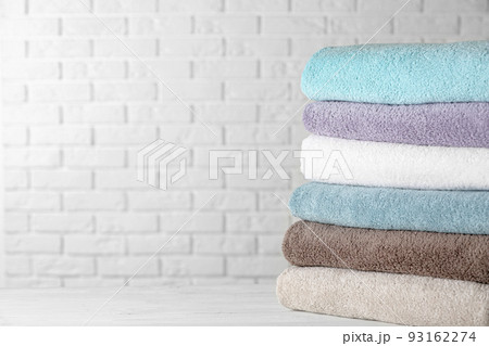 Stack of clean bath towels on white wooden table. Space for text 93162274