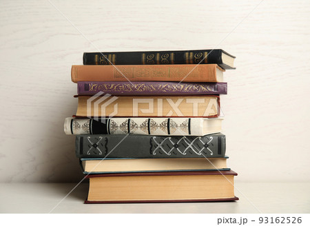 Collection of different books on table against white wooden background Collection of different books on table against white wooden background 93162526
