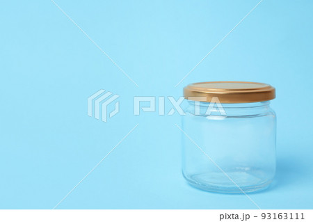 Closed empty glass jar on light blue background, space for text Closed empty glass jar on light blue background, space for text 93163111