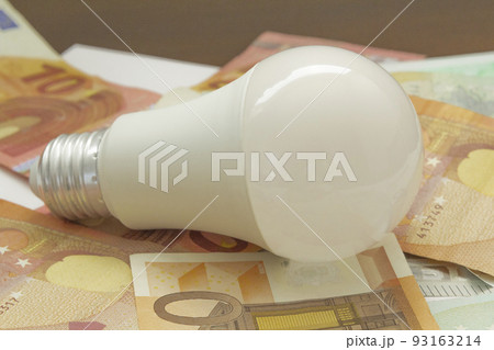 light bulb and euro banknotes. electricity price concept, increasing the energy costs, save electricity, horizontal closeup 93163214