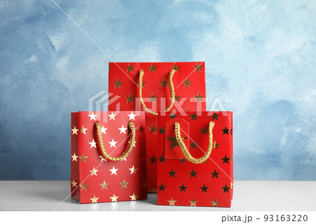 Red shopping paper bags with star pattern on white table Red shopping paper bags with star pattern on white table 93163220