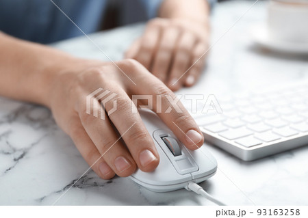 Woman using wired computer mouse at marble table, closeup Woman using wired computer mouse at marble table, closeup 93163258