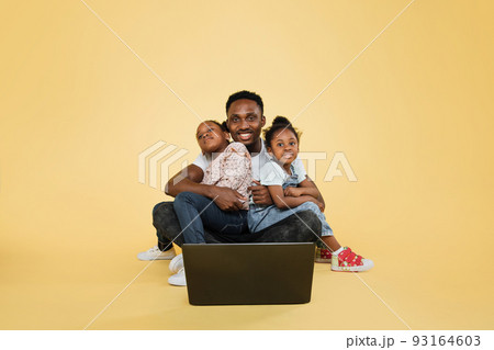 Happy african american daddy and his two little cute daughters spending time together using laptop Happy african american daddy and his two little cute daughters spending time together using laptop 93164603