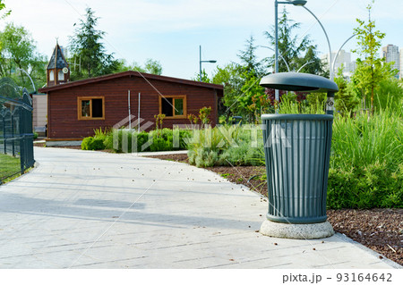 Green metal trash bin in a city 93164642