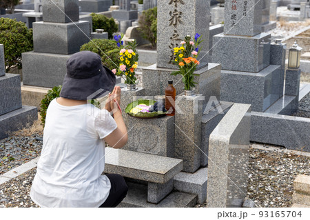 お墓参りに来て、これからお墓をどうしようかと思案している中高年女性 93165704