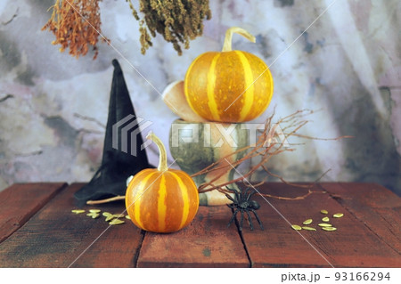 Happy Halloween, pumpkins, mortar, healing plants, witch hat and dry branches on sunset background, composition, home decoration concept 93166294