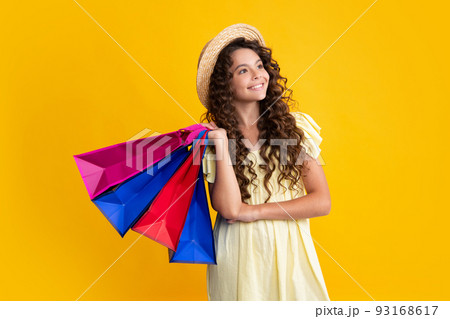 Sale and shopping concept. Teen girl holding shopping bags, isolated on studio background. Happy teenager, positive and smiling emotions of teen girl. 93168617