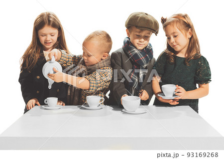 Portrait of beautiful children, boys and girls in stylish autumn clothes isolated over white studio background. Tea party. Portrait of beautiful children, boys and girls in stylish autumn clothes isolated over white studio background. Tea party. 93169268