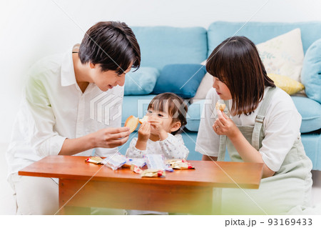 リビングでお菓子を食べる親子 93169433