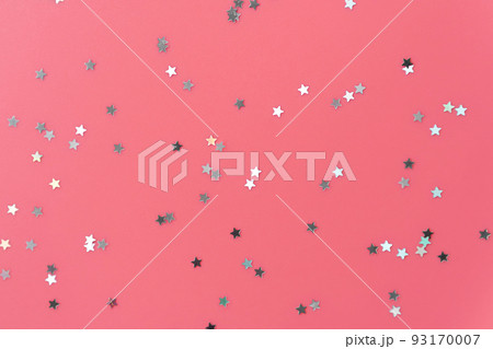 Silver stars glittering confetti on pink background. Trendy festive holiday backdrop. Many star-shaped particles for a postcard, invintation or web banner 93170007