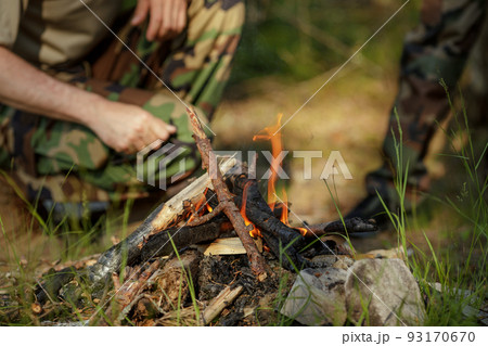 Man is making campfire in the woods. The concept of adventure, travel, tourism, camping, survival and evacuation. 93170670