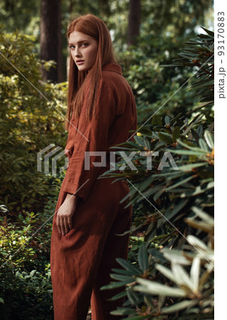 Young women with ginger hair in ecologically grown linen clothes in Japanese garden Young women with ginger hair in ecologically grown linen clothes in Japanese garden 93170883
