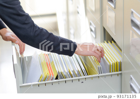 机の引き出しの中から、書類を探している手のアップ 机の引き出しの中から、書類を探している手のアップ 93171135