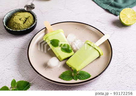 Vegetarian popsicle made from matcha tea, coconut milk and mint on a plate. Close-up Vegetarian popsicle made from matcha tea, coconut milk and mint on a plate. Close-up 93172256