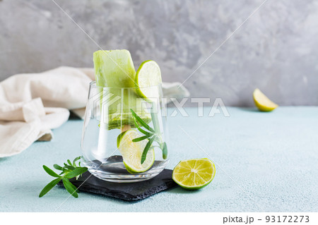 Diet popsicle made from avocado and lime in a glass on the table. Homemade desserts 93172273
