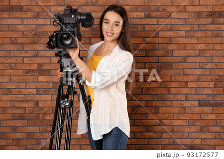 Operator with professional video camera near brick wall, space for text Operator with professional video camera near brick wall, space for text 93172577
