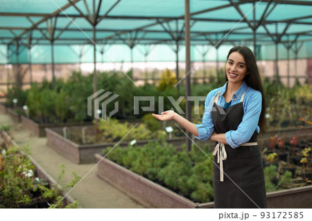 Female business owner showing her greenhouse. Space for text 93172585