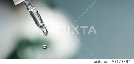 Banner. Pipette with serum, hyaluronic acid close up on blue background. Drop falling from pipet. Cosmetics, healthcare concept. Essential oill, retinol. Beauty product presentation, front view, macro Banner. Pipette with serum, hyaluronic acid close up on blue background. Drop falling from pipet. Cosmetics, healthcare concept. Essential oill, retinol. Beauty product presentation, front view, macro 93173394