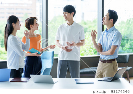 オフィスで雑談をするカジュアルなビジネスパーソン 93174546