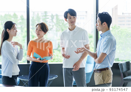 オフィスで雑談をするカジュアルなビジネスパーソン 93174547