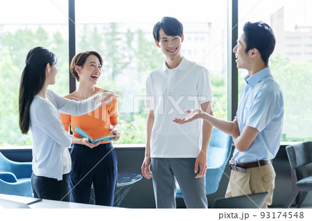 オフィスで雑談をするカジュアルなビジネスパーソン 93174548