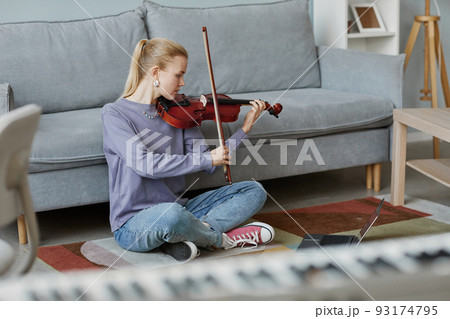 Young Woman Practicing Violin at Home Young Woman Practicing Violin at Home 93174795
