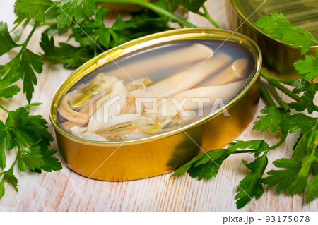 Tasty natural navajas in open tin can served with greens and lemon 93175078