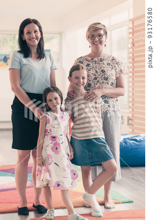 Portrait of a mother with her daughters in a modern preschool institution. Selective focus Portrait of a mother with her daughters in a modern preschool institution. Selective focus 93176580