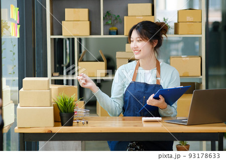 Young asian businesswoman onwer checking parcels list before delivering to customers. 93178633