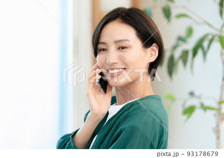 スマートフォンで通話する女性【リビング】 スマートフォンで通話する女性【リビング】 93178679