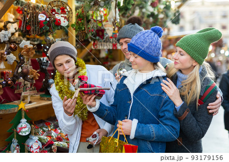 Family of four choosing decorations at Christmas fair 93179156