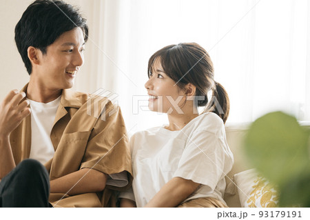 同棲・新婚イメージ、ソファに座る笑顔のカップル 93179191