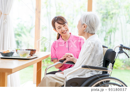 食事するシニア女性とヘルパーの女性 食事するシニア女性とヘルパーの女性 93180037