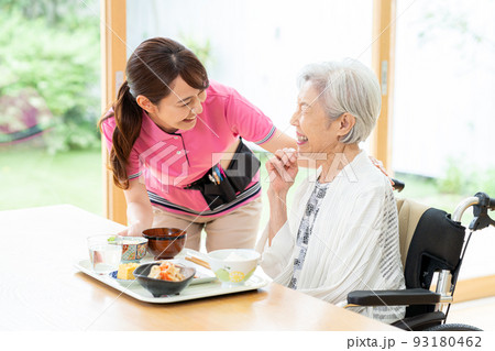 食事するシニア女性とヘルパーの女性 93180462