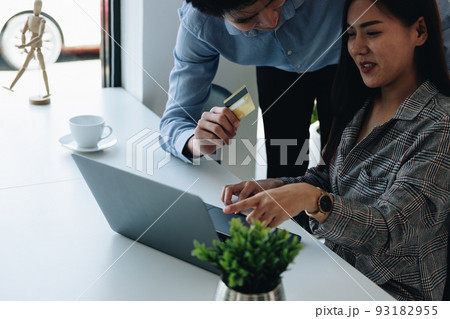 Asian couple at home shopping online with laptop and credit card Asian couple at home shopping online with laptop and credit card 93182955