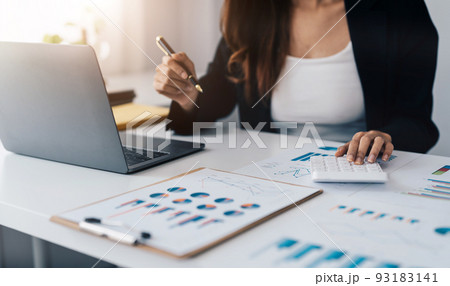 Close up asian woman planning budget, using calculator and laptop, reading documents, young female checking finances, counting bills or taxes, online banking services, sitting at desk 93183141