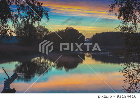 Rural nature landscape. Sunset over the lake. Magic colorful sunset in the countryside. Rural landscape in the evening. Beautiful summer nature 93184416