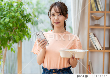 お弁当とスマホを持つ若い女性 お弁当とスマホを持つ若い女性 93184637
