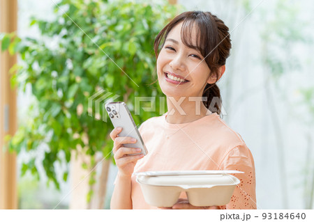 お弁当とスマホを持つ若い女性 お弁当とスマホを持つ若い女性 93184640