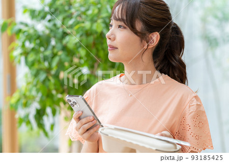 お弁当とスマホを持つ若い女性 お弁当とスマホを持つ若い女性 93185425