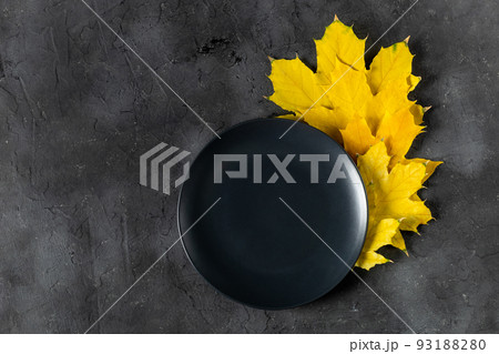 Autumn table setting with bright colorful leaves and black plate. Flat lay. 93188280