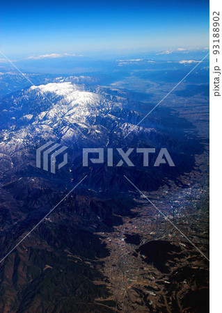 雪山の山頂の連なりとその手前の平地、山々の冬景色と手前の幾つかの湖が飛行機の窓から 雪山の山頂の連なりとその手前の平地、山々の冬景色と手前の幾つかの湖が飛行機の窓から 93188902