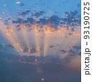 Blue and orange sunset sky with rays of sun going through clouds. 93190725