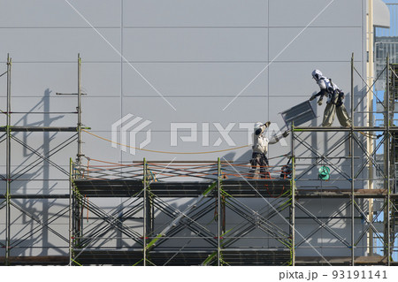 工事現場　とび職人　流通倉庫の仮設足場撤去作業風景 93191141