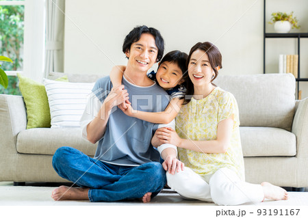 リビングでくつろぐ若い家族 93191167