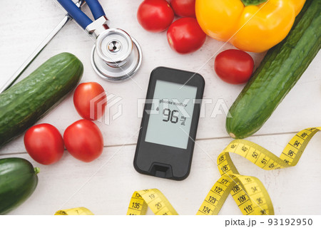 Glucometer with fresh vegetables. Diabetes concept Glucometer with fresh vegetables. Diabetes concept 93192950